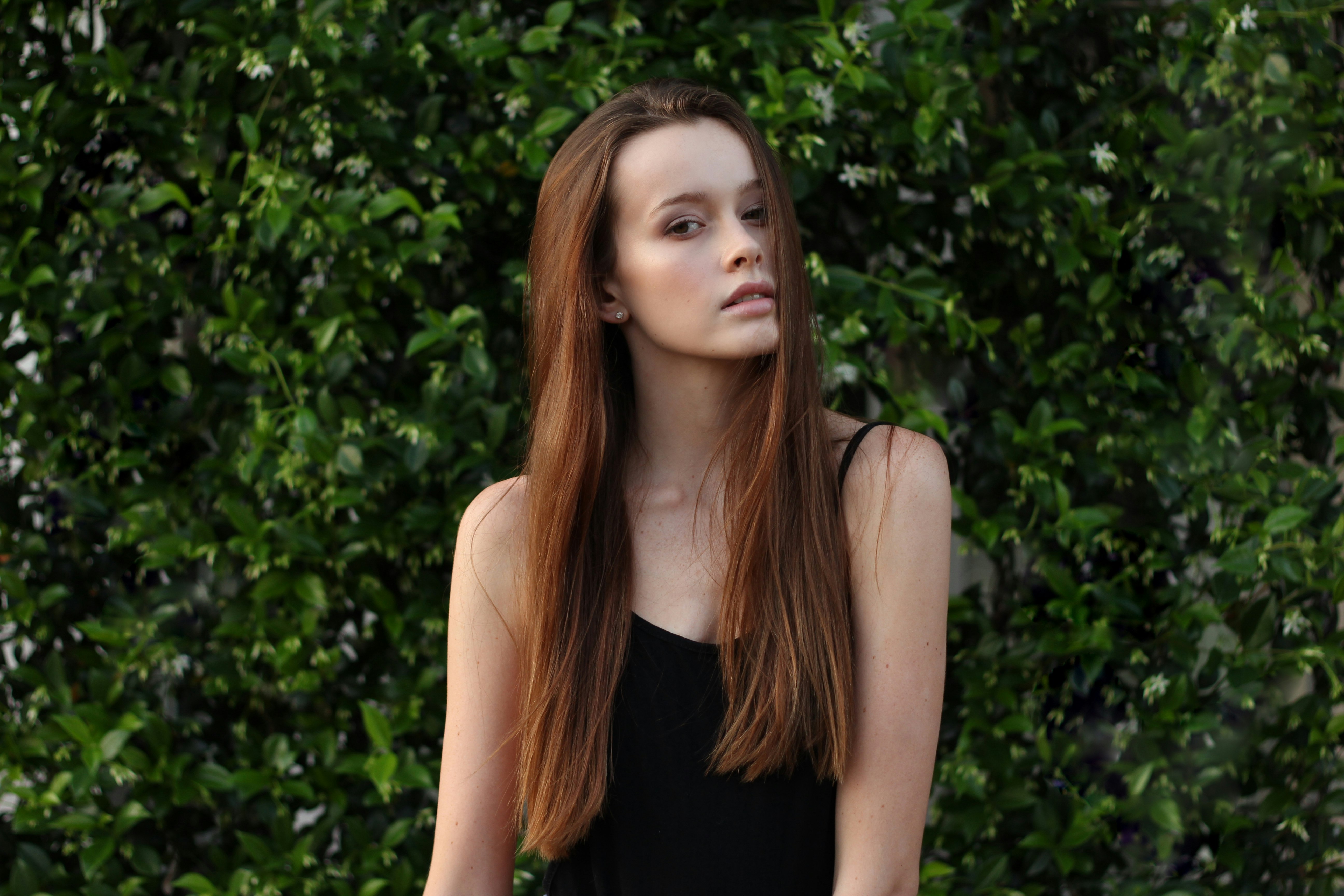 woman wearing spaghetti strap top in front of bush